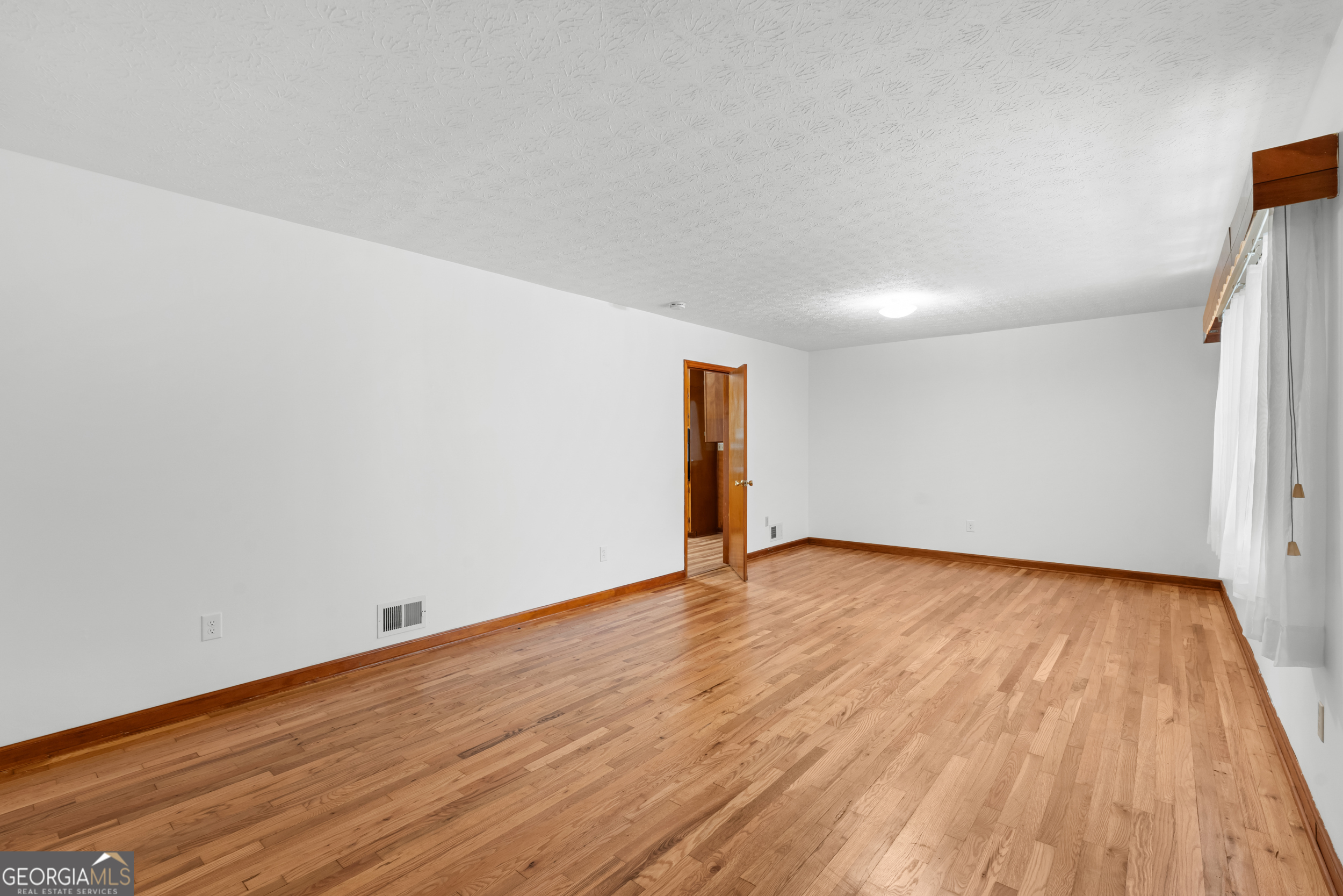 181 Heidt Road Guyton, GA 31312 - Photo 3 of 24 a view of an empty room and wooden floor