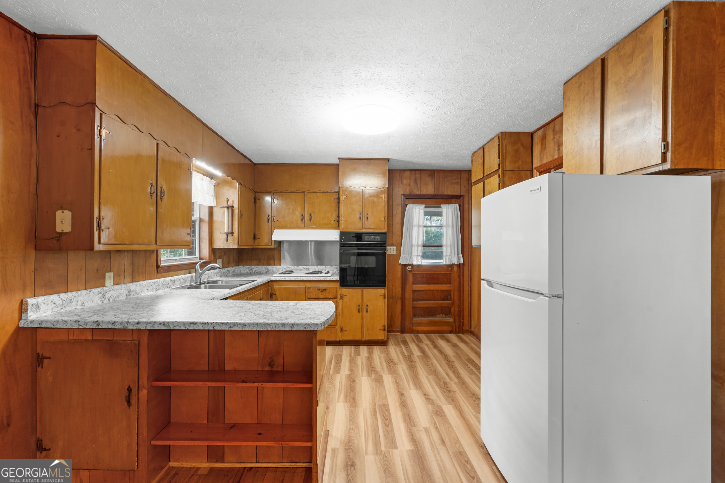 181 Heidt Road Guyton, GA 31312 - Photo 7 of 24 a kitchen with stainless steel appliances granite countertop a refrigerator a oven and white cabinets with wooden floors