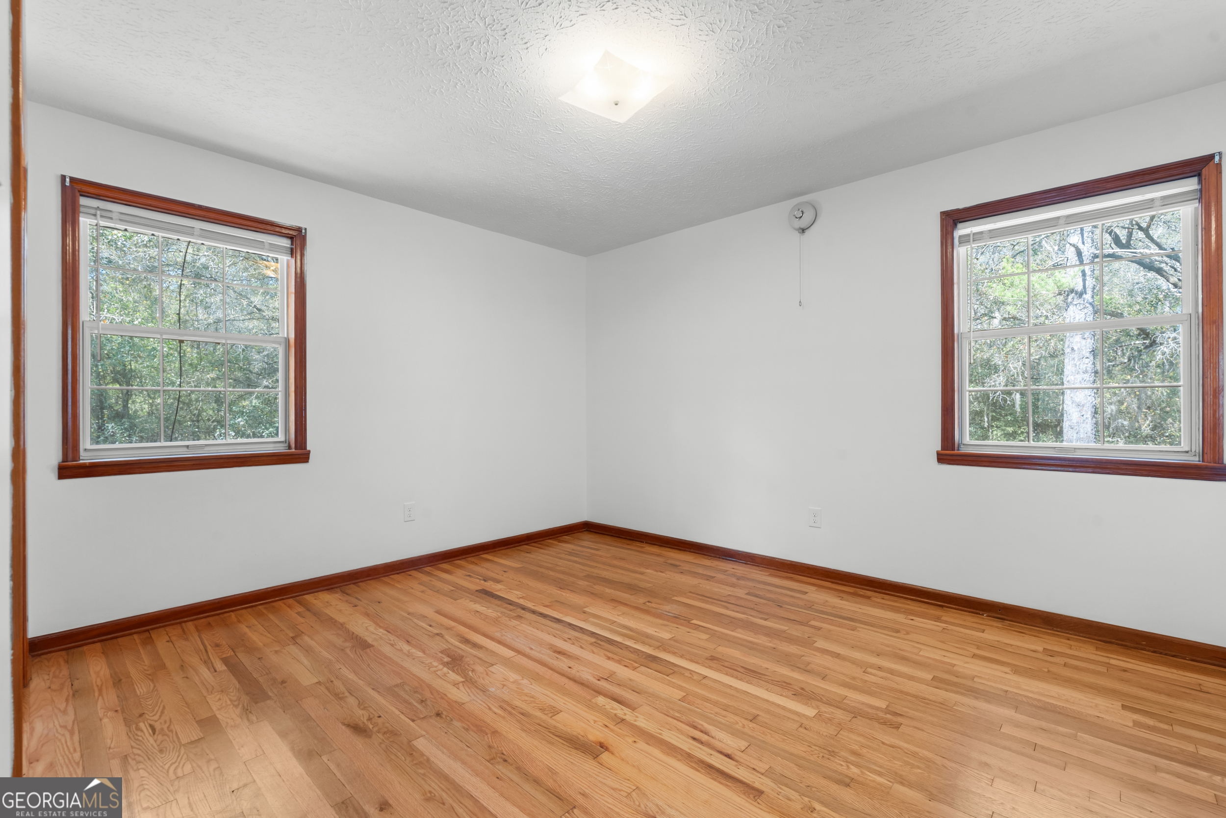 181 Heidt Road Guyton, GA 31312 - Photo 10 of 24 a view of an empty room with wooden floor and a window
