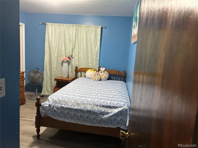 a bedroom with a bed and wooden floor