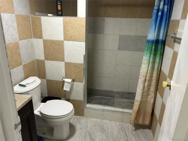 a white toilet sitting next to a bath tub and a shower