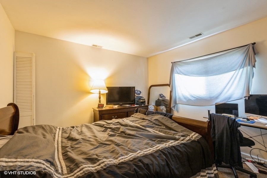 209 Bedford Road Bolingbrook, IL 60440 - Photo 10 of 11 a bedroom with a bed and a flat screen tv