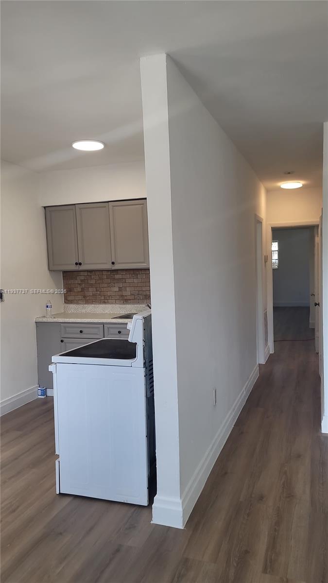 2951 Northwest 49th Street Miami, FL 33142 - Photo 11 of 19 a kitchen with wooden floor and stainless steel appliances