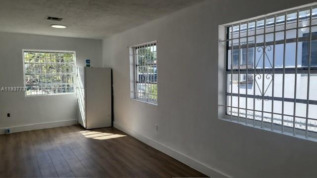 2951 Northwest 49th Street Miami, FL 33142 - Photo 18 of 19 an empty room with wooden floor and windows