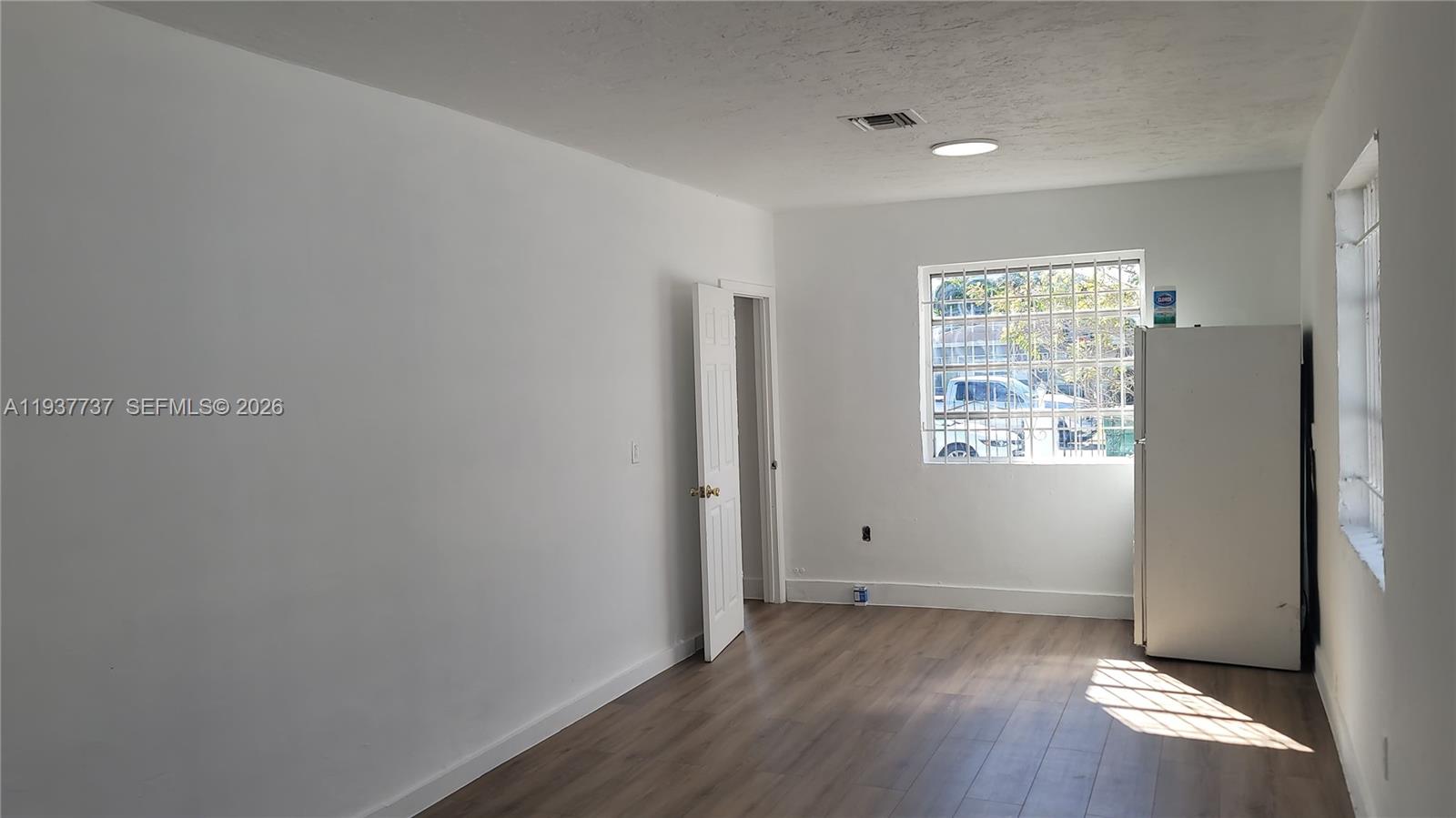 2951 Northwest 49th Street Miami, FL 33142 - Photo 19 of 19 an empty room with wooden floor and windows