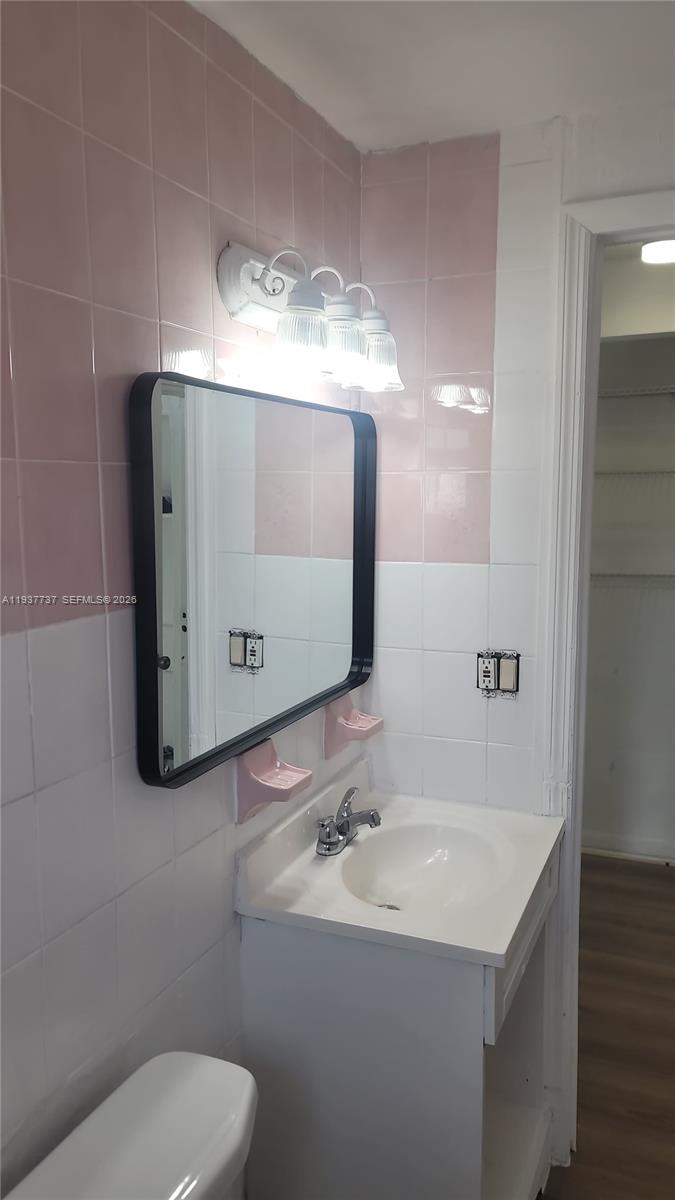 2951 Northwest 49th Street Miami, FL 33142 - Photo 8 of 19 a bathroom with a sink and mirror with toilet
