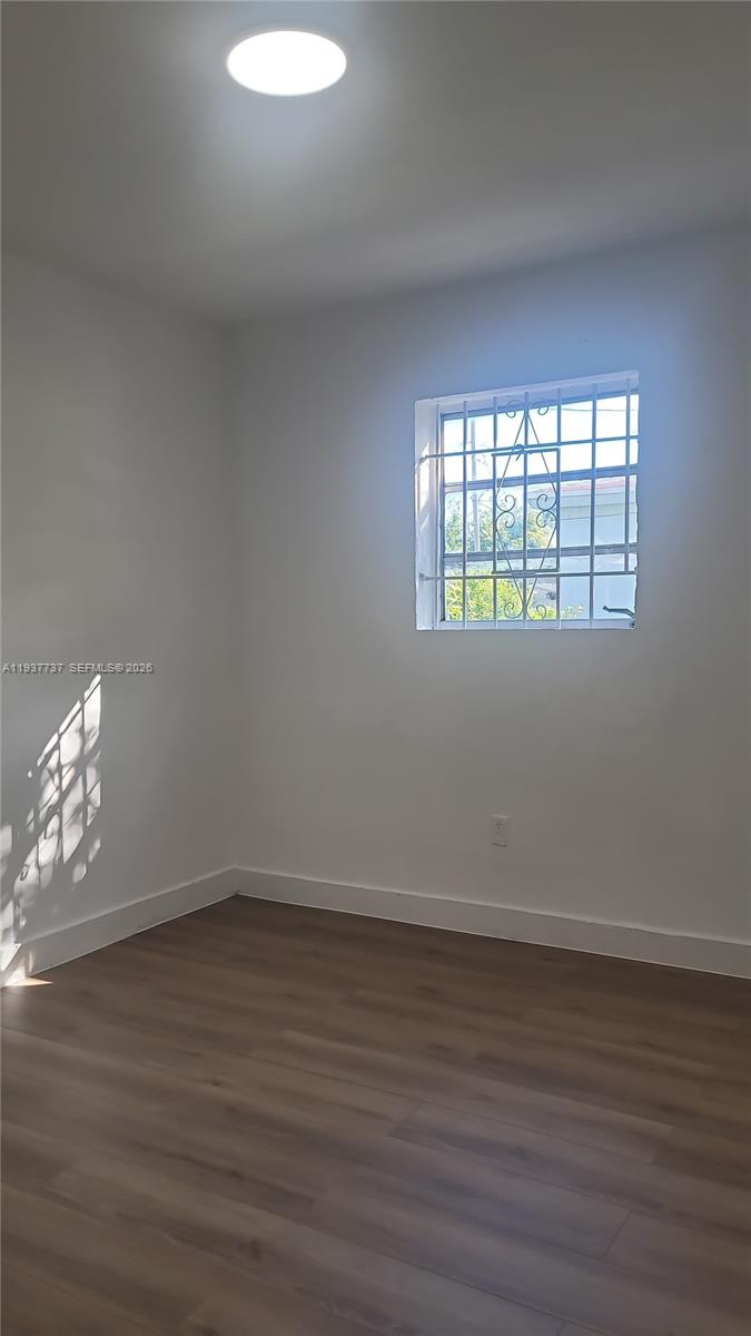 2951 Northwest 49th Street Miami, FL 33142 - Photo 9 of 19 a view of an empty room with wooden floor and a window