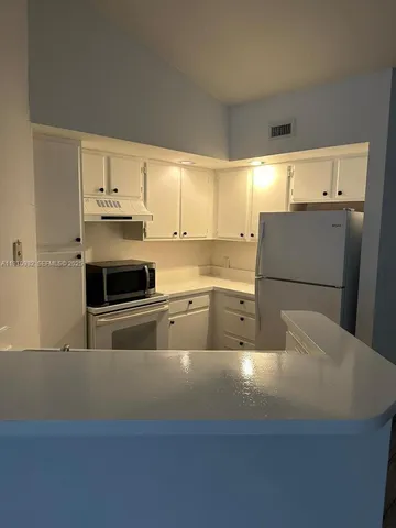 a kitchen with stainless steel appliances a refrigerator sink and microwave