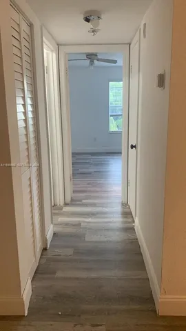 a view of a hallway with wooden floor and staircase