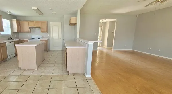 a kitchen with a sink a refrigerator and cabinets