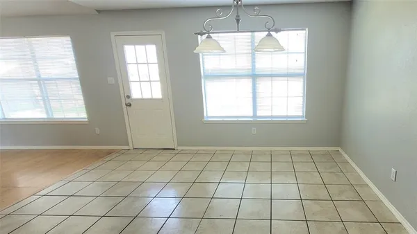 an empty room with windows and chandelier