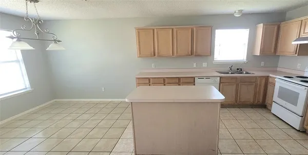 a kitchen with a sink a stove and cabinets