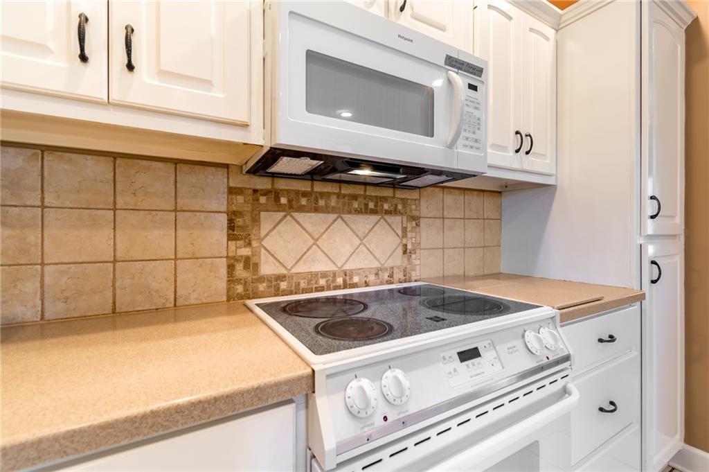 6628 Windvane Point Clermont, GA 30527 - Photo 13 of 41 a kitchen with granite countertop white cabinets and a stove