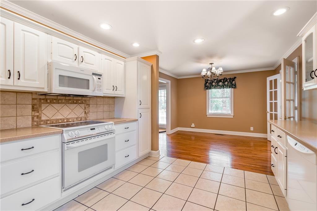 6628 Windvane Point Clermont, GA 30527 - Photo 14 of 41 a kitchen with stainless steel appliances granite countertop a stove a sink and a refrigerator