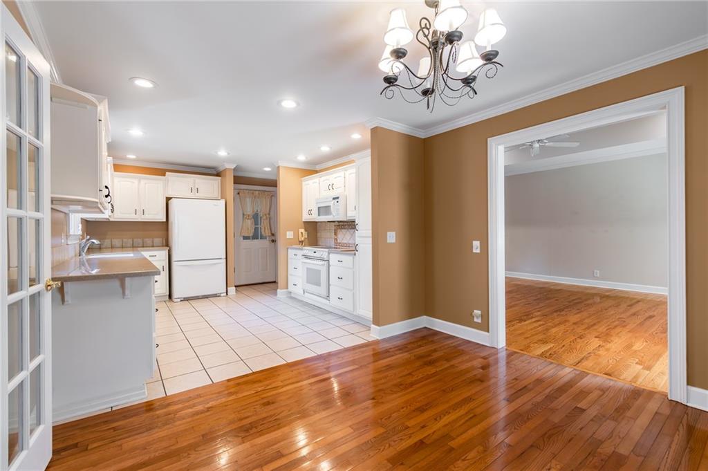 6628 Windvane Point Clermont, GA 30527 - Photo 17 of 41 a view of a kitchen with kitchen island granite countertop wooden floor and a refrigerator
