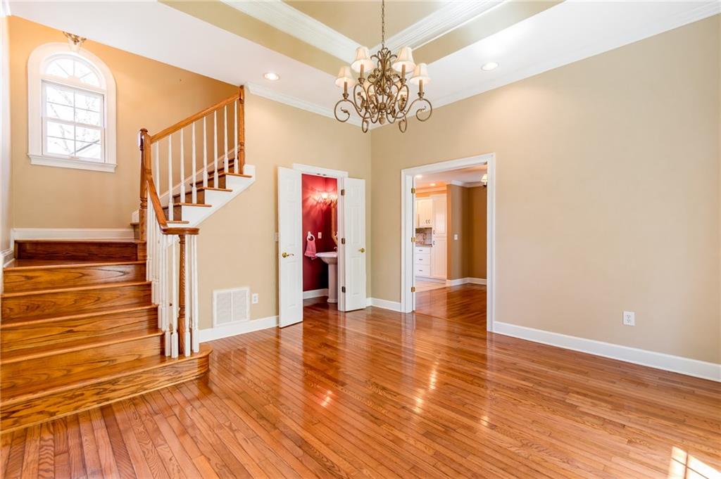 6628 Windvane Point Clermont, GA 30527 - Photo 20 of 41 a view of an entryway with wooden floor and a chandelier