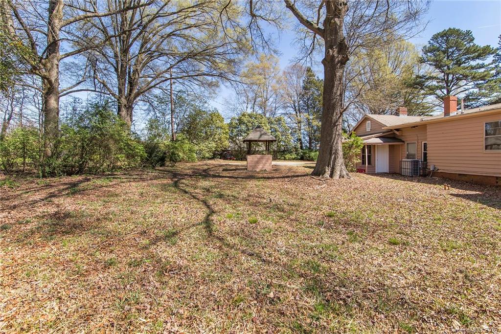 5132 Tuckaseegee Road Charlotte, NC 28208 - Photo 14 of 15 a backyard of a house with large trees