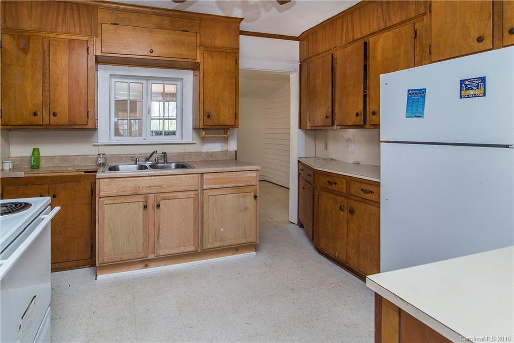5132 Tuckaseegee Road Charlotte, NC 28208 - Photo 7 of 15 a kitchen with a sink a stove and cabinets