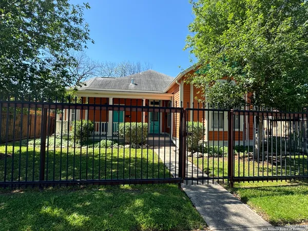 a view of a house in front of a yard with plants and trees