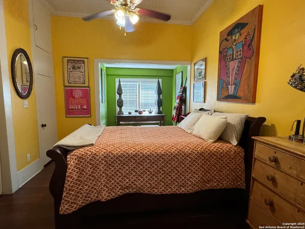 a bedroom with a bed and painting on the wall