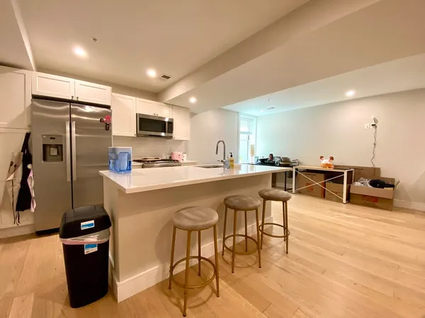 a kitchen with stainless steel appliances kitchen island granite countertop a refrigerator and a stove top oven