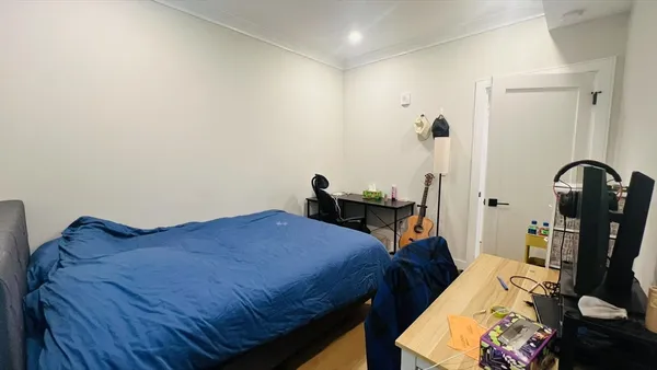 a bedroom with a bed and wooden floor