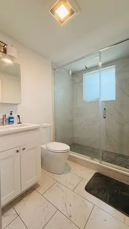 a bathroom with a sink a toilet and shower