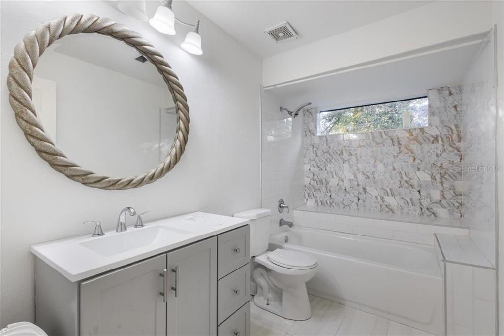 5609 Northwest 53 Court Gainesville, FL 32653 - Photo 32 of 49 a bathroom with a sink a toilet and a mirror