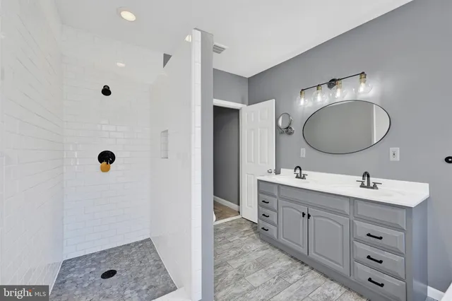 a bathroom with a double vanity sink a mirror and a shower