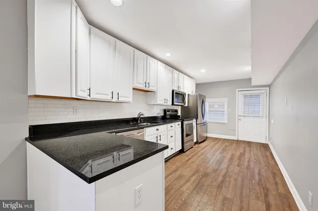 a kitchen with granite countertop a sink stove and refrigerator