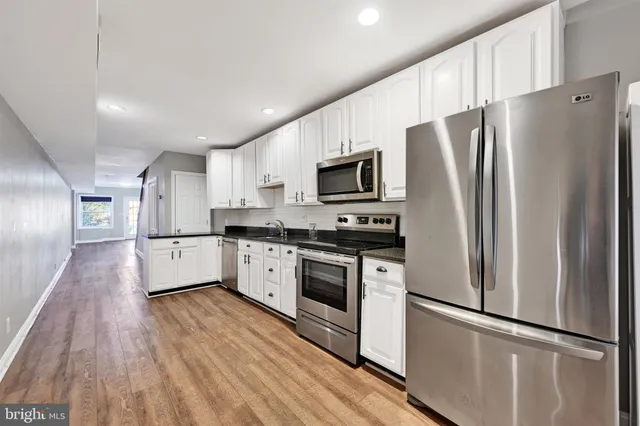 a kitchen with stainless steel appliances a refrigerator sink and microwave