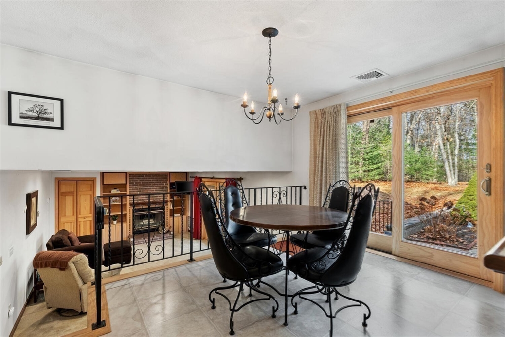 13 Dix Road Ipswich, MA 01938 - Photo 11 of 30 a dining room with furniture wooden floor a rug a potted plant and a chandelier