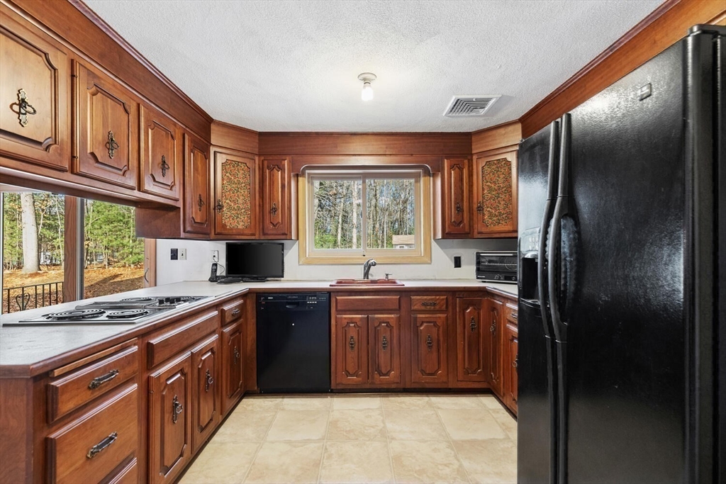 13 Dix Road Ipswich, MA 01938 - Photo 8 of 30 a kitchen with stainless steel appliances granite countertop a refrigerator a sink dishwasher a stove a washer and dryer next to a window