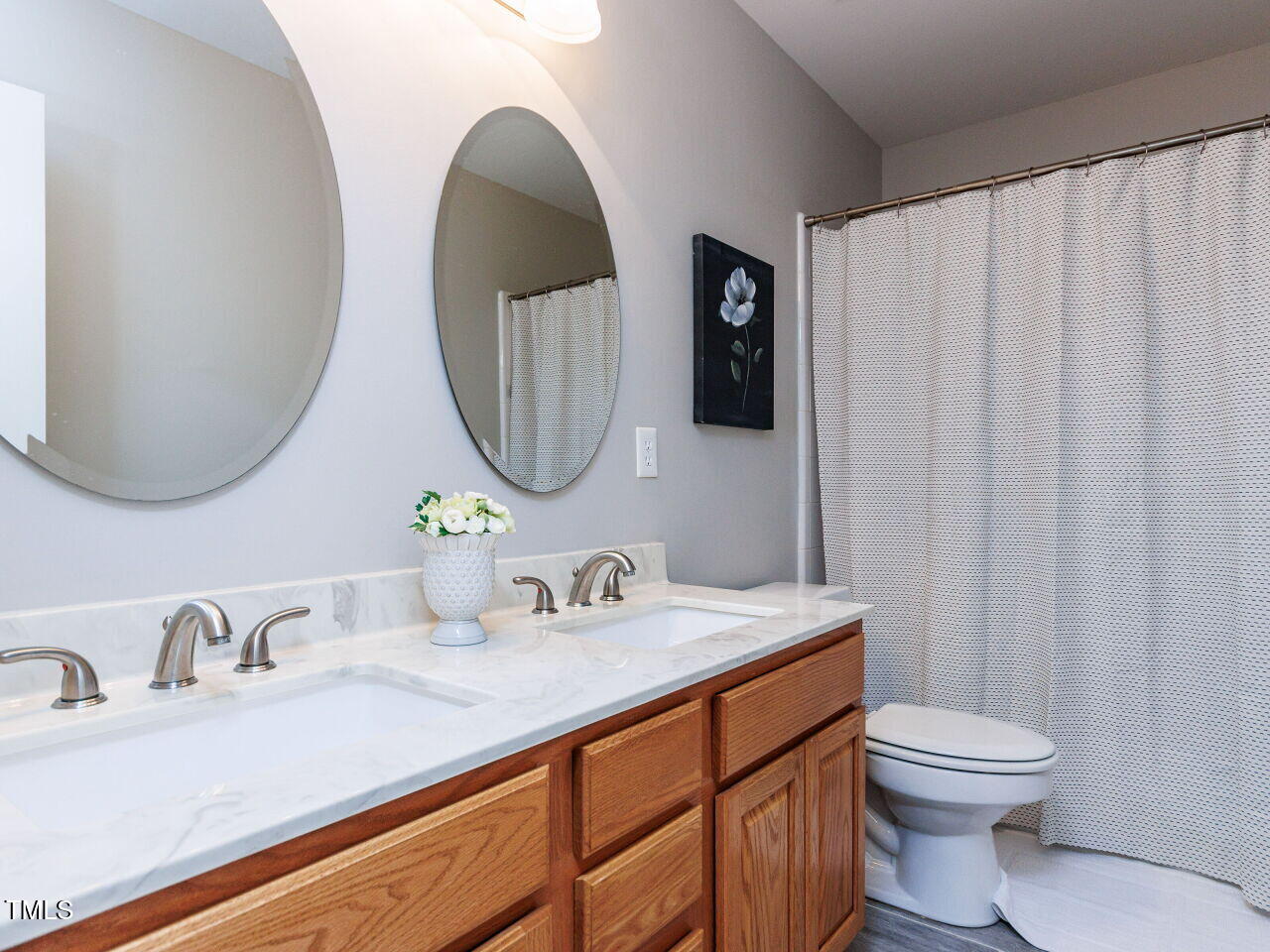 6516 Englehardt Drive Raleigh, NC 27617 - Photo 32 of 43 Hall bath with double vanity, updated counter tops, oval mirrors. plumbing fixtures, tub/bath combo, new vertical tile flooring.
