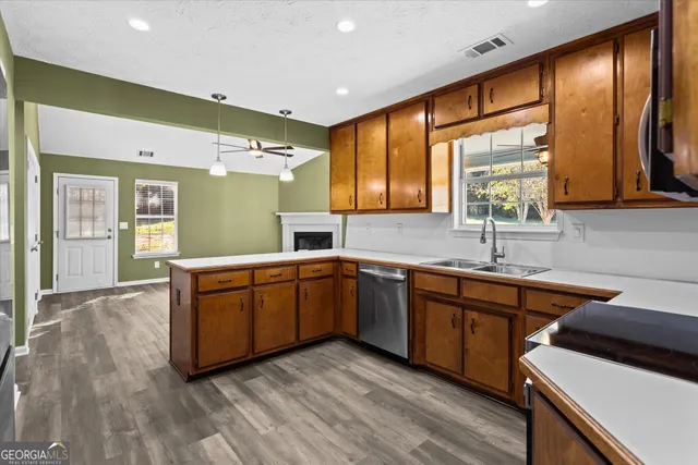a large kitchen with stainless steel appliances granite countertop a sink and wooden cabinets