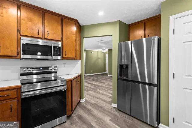 a kitchen with stainless steel appliances granite countertop wooden cabinets a stove top oven a sink and dishwasher