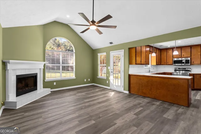 a view of a livingroom with a chandelier fan and a window