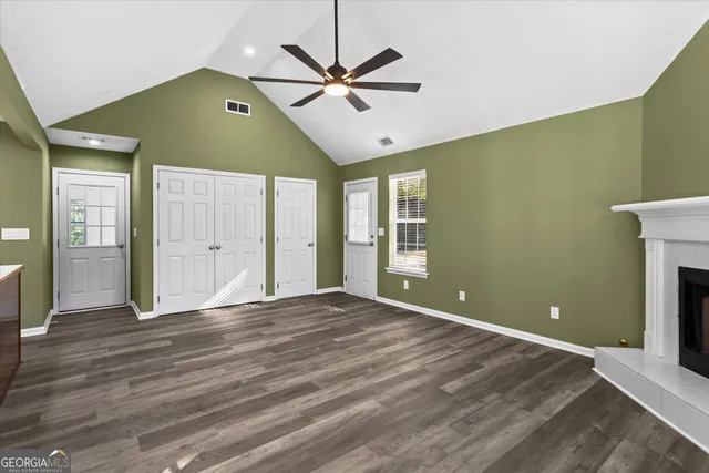 a view of a hallway with wooden floor and closet area