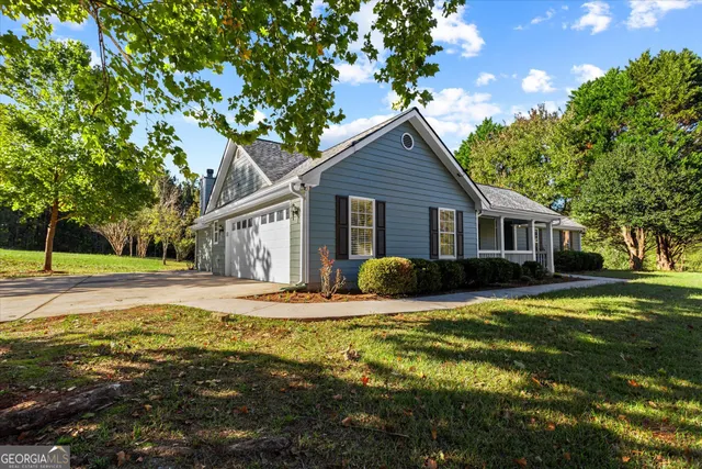 a view of house with backyard and trees