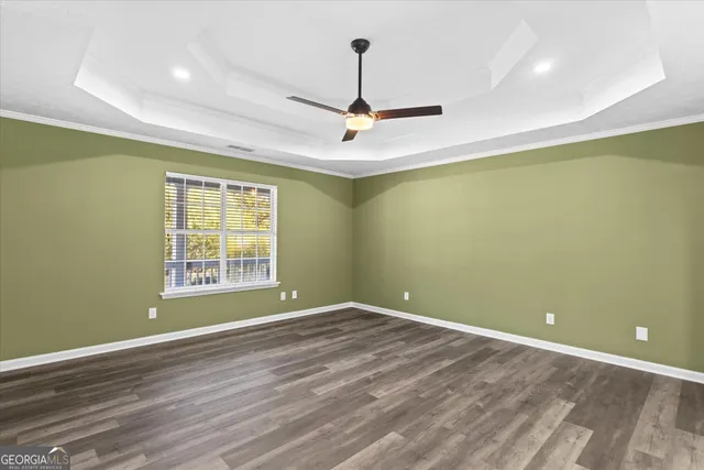 an empty room with a window and a ceiling fan