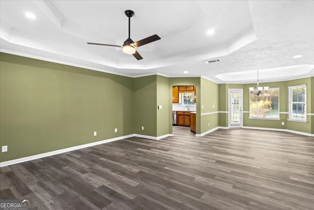 a view of an empty room with window and wooden floor