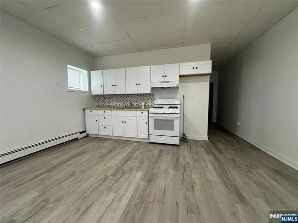 a view of a kitchen with stove and cabinets