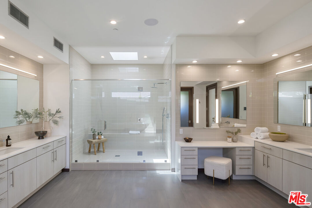 15641 Meadowgate Road Encino, CA 91436 - Photo 22 of 32 a bathroom with a double vanity sink mirror and shower