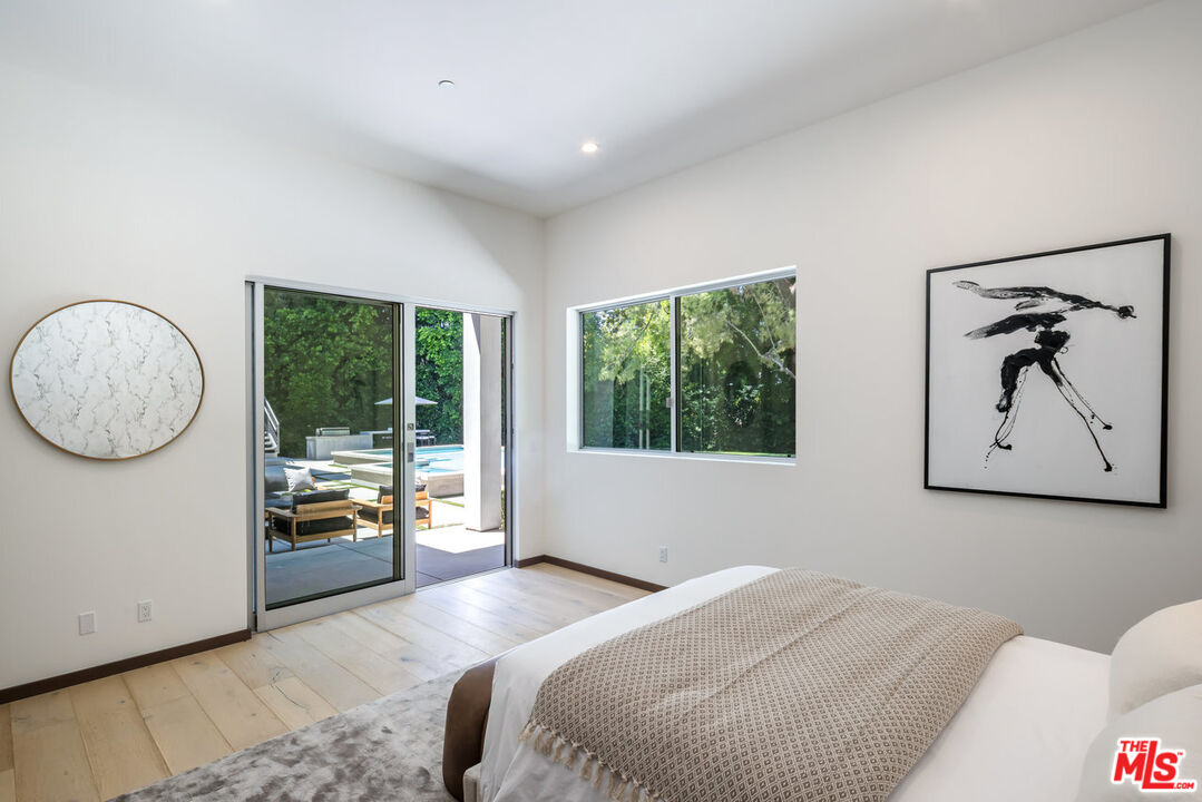 15641 Meadowgate Road Encino, CA 91436 - Photo 27 of 32 a bedroom with a bed and a large window