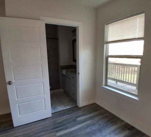 814 Chestnut Street Bonham, TX 75418 - Photo 5 of 12 an empty room with wooden floor closet and windows