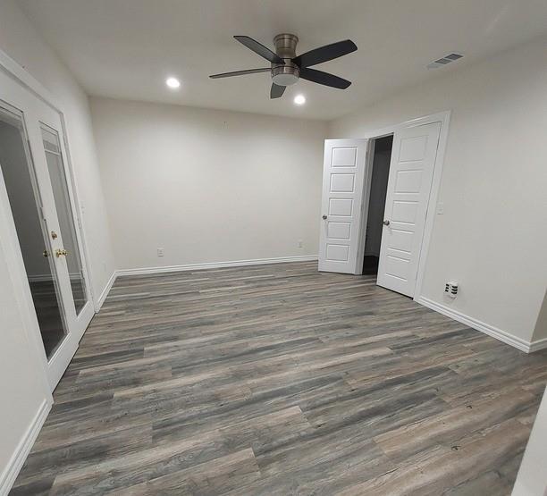 814 Chestnut Street Bonham, TX 75418 - Photo 10 of 12 an empty room with wooden floor and a ceiling fan