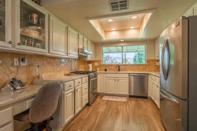a kitchen with granite countertop a sink stainless steel appliances and cabinets