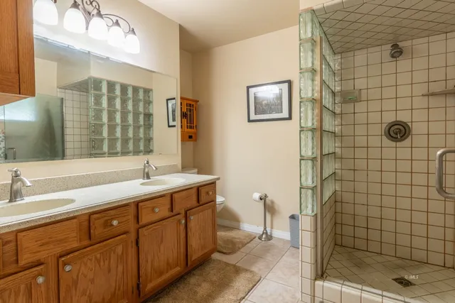 a bathroom with a double vanity sink a toilet and a mirror