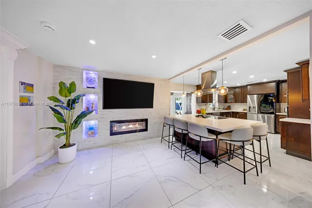 a living room with furniture a flat screen tv and a potted plant