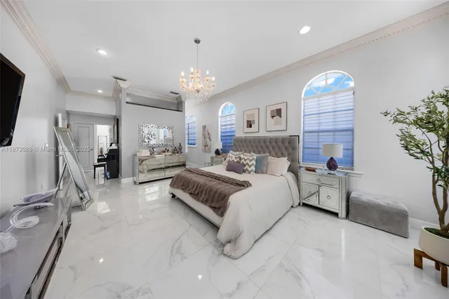 a spacious bedroom with a large bed and a chandelier